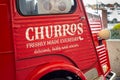 Close up of side front door of red Churros food van at Ashford Outlet Centre in April 2022.