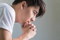 Close up side of handsome man sitting with his hands under his chin thoughtfully in home