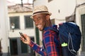 Close up side of happy african american man with backpack and cellphone Royalty Free Stock Photo