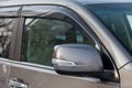 Close-up of the side left mirror with rear veiw 3d camera and window of the car body gray SUV on the parking after washing in auto