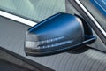 Close-up of the side left mirror with turn signal repeater and window of the car body black SUV on the street parking after Royalty Free Stock Photo