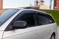 Close-up of the side left mirror and the window of the car body of a gray sedan in a street parking lot after washing and Royalty Free Stock Photo