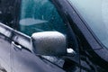 Close-up of side mirror of snow covered blue car Royalty Free Stock Photo