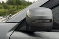 Close up side mirror wing cover material of gray car is foldable parking time. by automatic from system.