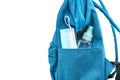 Close up side pocket of blue student backpack with face mask and a small bottle of alcohol, side view backpack, isolated image on