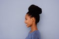 Young girl with braided hair in a bun by gray wall Royalty Free Stock Photo