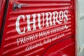 Close up of side of red Churros food van at Ashford Outlet Centre in April 2022.