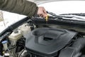 Close-up side view of auto mechanic man checking engine oil level in car, workshop, garage. car repairing service with Royalty Free Stock Photo