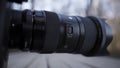 Close up side view of a black plastic camera lens on blurred background outdoors. Action. Demonstration of photographer Royalty Free Stock Photo