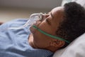 Close up side view of black senior woman with oxygen support mask in hospital Royalty Free Stock Photo