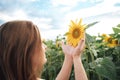 Close up side view of Caucasian woman holding sunflower in farm during spring season Royalty Free Stock Photo