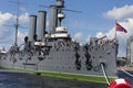 Close up side view of Cruiser Aurora with naval jack flag and forecastle gun on a summer day blue sky background. Royalty Free Stock Photo