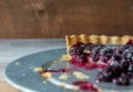 Close up side view of a dark berry tart made with blackberries and blueberries on a galvanized tray. Copy space.