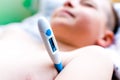 Close up side view flu sick lying down schoolboy with medical thermometer in armpit health illness Royalty Free Stock Photo