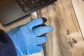 Close up side view of a hand in a blue glove using a computer mouse Royalty Free Stock Photo