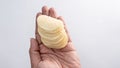 Hand Holding a Stack of Golden Round Potato Chips Against a Bright White Background Royalty Free Stock Photo
