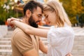 Close-up side view of happy young couple in love touching each other foreheads hugging standing in amusement park in Royalty Free Stock Photo