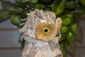 Close-up side view of head of decorative owl made of bark against a dark blurred background Royalty Free Stock Photo