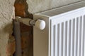 Close-up side view of installed heating radiator on brick rough plastered wall in an empty room of a newly built apartmen Royalty Free Stock Photo