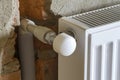 Close-up side view of isolated installed heating radiator on brick rough plastered wall in an empty room of a newly built Royalty Free Stock Photo