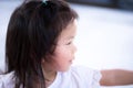 Close Up side view little cute child sweet smile. Candid happy Asian girl. Children aged 3-4 year old wearing white shirt. Royalty Free Stock Photo