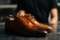 Close-up side view of old light brown leather shoe and repaired shiny shoes after restoration working. Royalty Free Stock Photo
