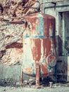 Close up side view of old rusted metal tank in abandoned industrial area.