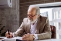 Close up side view shot of mature grey-haired man writing novel