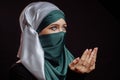 Close up side view shot of Muslim young woman in green hijab is praying the God Royalty Free Stock Photo