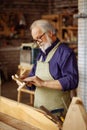 Close up side view shot of process creating wooden souvenirs for tourists