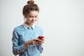 Close up side view shot of smiling nice female teenager with red cellphone