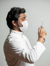 Close up side view sportrait of indian doctor with syringe is preparing for injection Royalty Free Stock Photo