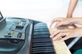 Close up side view of woman hands playing piano with hand of trainer blurry background. Royalty Free Stock Photo