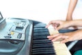 Close up side view of woman hands playing piano with hand of trainer blurry background. Royalty Free Stock Photo