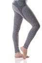 Close up side view of woman legs stretching the muscles of the foot in gray sports thermal underwear with pattern.