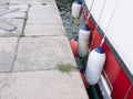 close-up of the side of the yacht white-red with weights close-up on the water stands. gray asphalt nearby