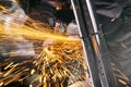 Close-up on the sides fly bright sparks from the angle grinder machine. Royalty Free Stock Photo