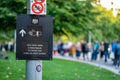 Close up of a sign for the Queen\'s Lying in State with a queue of people in the background in Jubilee Gardens on South Bank