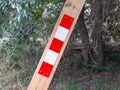 Close up of Signage on wooden stake in rural road. Wooden barrier of prohibited passage on the footpath. Beaconing signs. Trekking