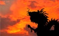 Close-up silhouette dragon statue from roof top of Chinese Temple on sunset sky background with copy space Royalty Free Stock Photo