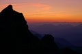 CLOSE UP: Silhouette of a mountaintop towering above dark landscape at twilight.