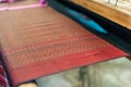 Close Up of Silk on the Weaving machine and Thai traditional Silk. Weaving loom for homemade Silk textile Royalty Free Stock Photo