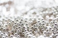 Close up of silver beads on shiny sequined texture Royalty Free Stock Photo