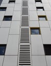 close up of silver colored metal cladding panels on a modern building with repeating windows and geometric grid design Royalty Free Stock Photo