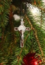 Silver cross with body of Jesus Christ on Christmas tree Royalty Free Stock Photo