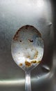 silver dirty used spoon with oil grease and meat and vegetable chunks left in the sink Royalty Free Stock Photo