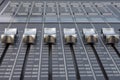 Close up of the silver faders of an audio mixer with gray background Royalty Free Stock Photo