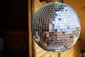 Close up of a silver reflective disco ball hanging outside