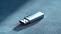 Close-up of a silver USB flash drive lying on a textured surface with soft lighting and shallow depth of field Royalty Free Stock Photo