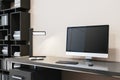 Close up of simple designer office interior with creative wooden bookcase, empty computer monitor and other items. Royalty Free Stock Photo